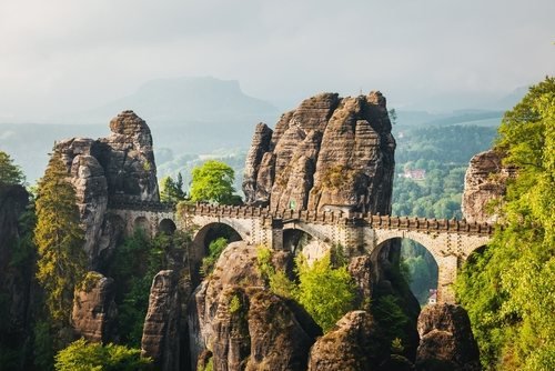 The stone Bastei Bridge between tall sandstone rocks in morning light