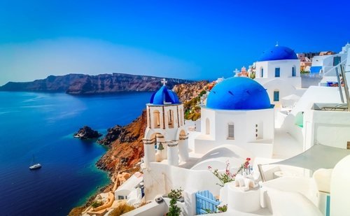 White church with blue domes above the Santorini caldera