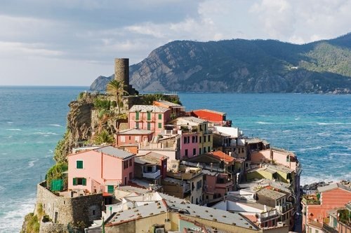 Colorful houses of Vernazza on a rock by the sea, with a round tower